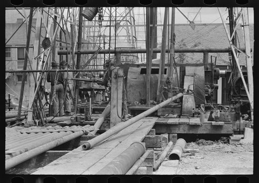 Untitled photo, possibly related to: Oil field workers releasing pipe wrenches from drill pipe, oil well, Kilgore, Texas
