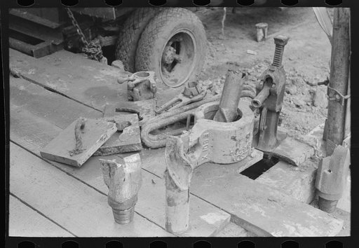 Untitled photo, possibly related to: Oil field workers talking together with bits in front of them, Kilgore, Texas