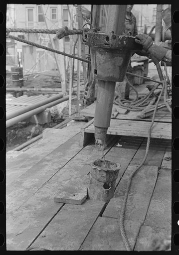 Pushing length of pipe into the rat hole, oil well, Kilgore, Texas