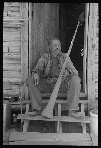 Old Negro (former slave) Willis Winn with horn with which slaves were called. Near Marshall, Texas