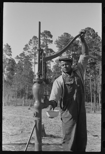 FSA (Farm Security Administration) client pumping water from his sanitary well, Sabine Farms, Marshall, Texas
