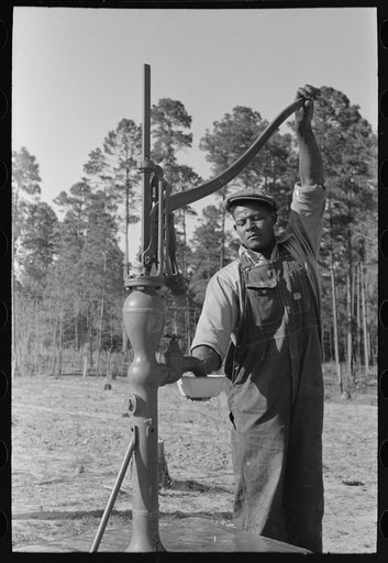 Untitled photo, possibly related to: FSA (Farm Security Administration) client pumping water from his sanitary well, Sabine Farms, Marshall, Texas
