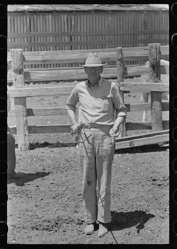 Owner of the "Walking X" ranch holding his branding iron on ranch near Marfa, Texas