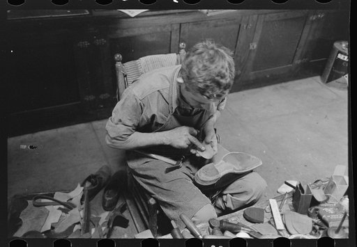 Untitled photo, possibly related to: Applying glue to heel before putting on another piece of leather. Bootmaking shop, Alpine, Texas