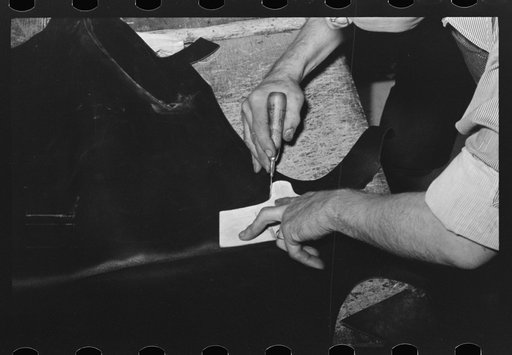 Cutting out heel of the upper from piece of leather. Bootmaking shop, Alpine, Texas
