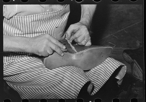 Trimming excess leather from sole. Cowboy bootmaking shop, Alpine, Texas