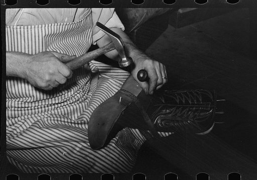 Untitled photo, possibly related to: Attaching piece of leather in arch of sole by means of wooden pegs. Cowboy bootmaking shop, Alpine, Texas