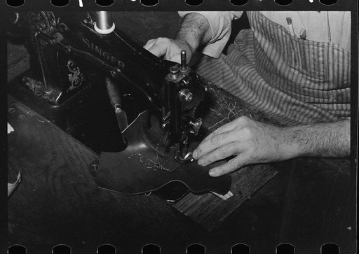 Untitled photo, possibly related to: Putting piece of canvas into foot of boot. This is the only piece of cloth in the boots and holds the wrinkles and toe flower. Cowboy boot shop, Alpine, Texas