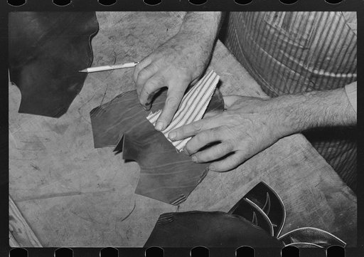 Putting piece of canvas into foot of boot. This is the only piece of cloth in the boots and holds the wrinkles and toe flower. Cowboy boot shop, Alpine, Texas
