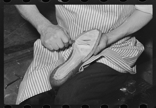 Trimming sole after second piece of leather has been attached with wooden pegs. Cowboy bootmaking shop, Alpine, Texas
