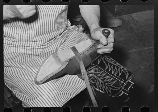 Attaching piece of leather in arch of sole by means of wooden pegs. Cowboy bootmaking shop, Alpine, Texas