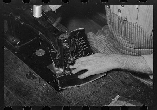Untitled photo, possibly related to: Attaching piece of leather in arch of sole by means of wooden pegs. Cowboy bootmaking shop, Alpine, Texas
