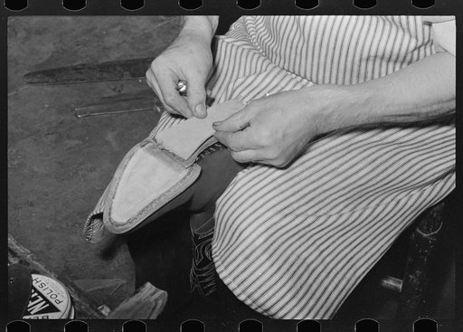 Attaching piece of leather into arch of sole before fasteining with wooden pegs. Bootmaking shop, Alpine, Texas