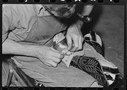 Roughening leather of lower part of boot before attaching upper with glue. Bootmaking shop, Alpine, Texas
