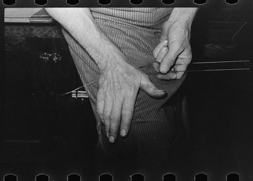 Untitled photo, possibly related to: Threading a needle with waxed thread. Bootmaking shop, Alpine, Texas