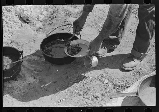 Cowboy dishing up chili at noonday dinner. Cattle ranch near Marfa, Texas