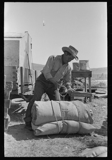 Cowboy tying up bedroll. Cattle ranch near Marfa, Texas