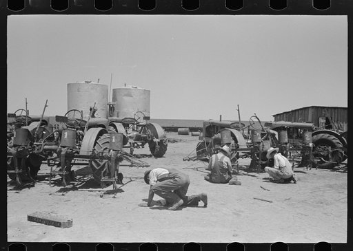 Part of the nine tractors on large farm near Ralls, Texas. The men working on them are day laborers who, with their families, live in shacks on the place