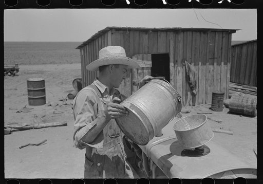 Pouring gasoline into tractor, large farm near Ralls, Texas. Man is day laborer
