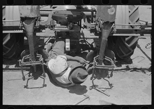 Adjusting plow points on tractor-drawn planter, large farm near Ralls