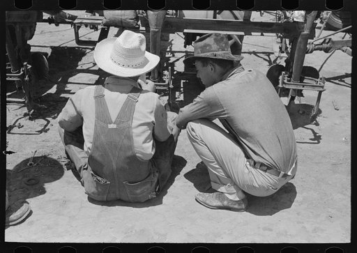 Day laborers at work on tractor, large farm near Ralls, Texas