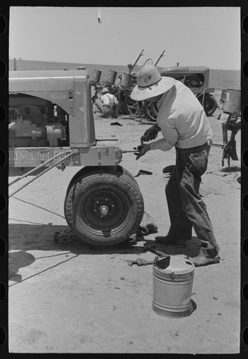 Untitled photo, possibly related to: Day laborer cranking tractor on farm near Ralls, Texas