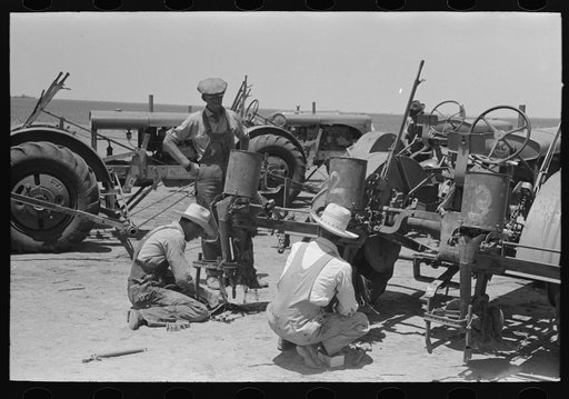 Day laborers working on tractors, large farm near Ralls, Texas