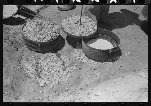 Biscuit being made in dutch oven on cattle ranch near Spur, Texas. Coals are piled on the lid of the dutch oven