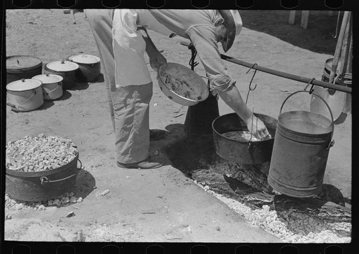 Untitled photo, possibly related to: Camp cook working over an open fire, cattle ranch near Spur, Texas. The old attitude of the inferiority of the cook on the range is still prevalent. This cook said "the boys treat me awfully good."