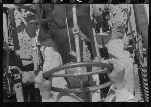 Day laborer on tractor on large farm near Ralls, Texas