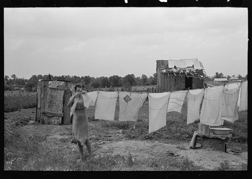 Untitled photo, possibly related to: Daughter of tenant farmer hanging up clothes near Warner, Oklahoma