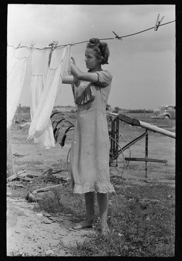 Daughter of tenant farmer hanging up clothes near Warner, Oklahoma