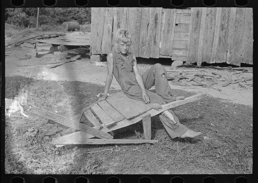 Son of day laborer resting on a wheel barrow, McIntosh County, Oklahoma