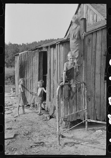 Untitled photo, possibly related to: Son of day laborer resting on a wheel barrow, McIntosh County, Oklahoma