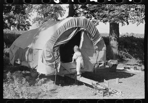 Child of white migrant going into covered wagon trailer, Wagoner County, Oklahoma