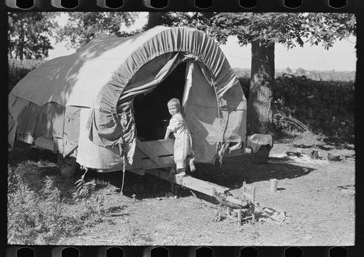 Untitled photo, possibly related to: Child of white migrant going into covered wagon trailer, Wagoner County, Oklahoma