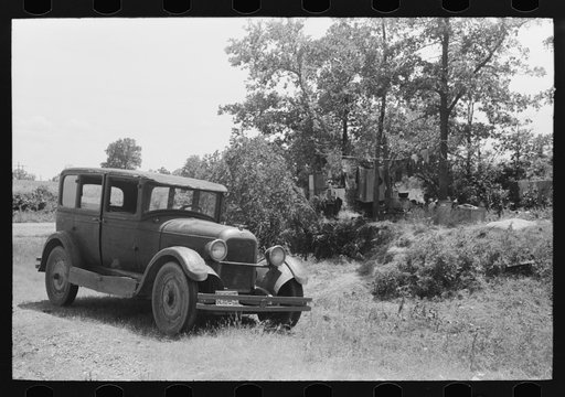 Automobile of family camped by the roadside while they did agricultural day labor in the neighborhood to secure funds to continue westward to Arizona and Califormia. This camp was near Spiro, Oklahoma