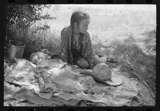 Children of agricultural day laborers camped by the roadside near Spiro, Oklahoma. There were no beds and no protection from the profusion of flies