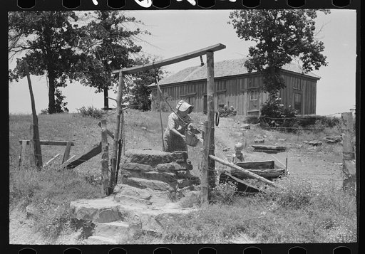 Tenant farmer drawing water at well. This woman (her husband died several months ago) and her three grown sons rent and farm about sixty acres near Sallisaw, Oklahoma