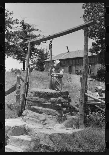 Untitled photo, possibly related to: Tenant farmer drawing water at well. This woman (her husband died several months ago) and her three grown sons rent and farm about sixty acres near Sallisaw, Oklahoma