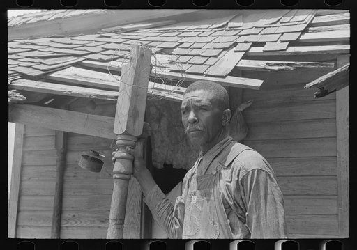 Negro tenant farmer on his front porch. This farm is owned by an out-of-state woman and has been rented by this family of Negroes for eleven years. The Negro man says that the agent is changed so often that no one ever takes any interest in the condition of the land or buildings. South of Muskogee, 