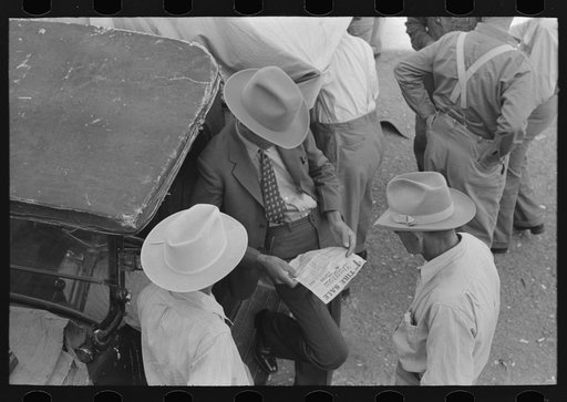 Farmers talking and looking at tire sale handbill, Weatherford, Texas