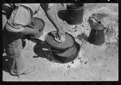 Lifting lid from kettle of chili made by the ranch cook at the roundup near Marfa, Texas