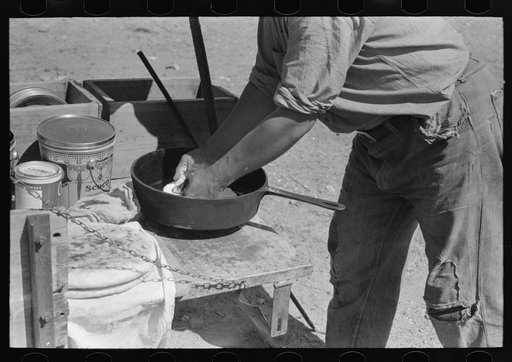 Placing bread in dutch oven to bake near Marfa, Texas