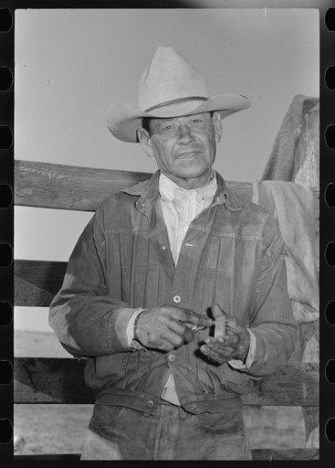 Mexican cowboy sharpening his knife. Roundup near Marfa, Texas