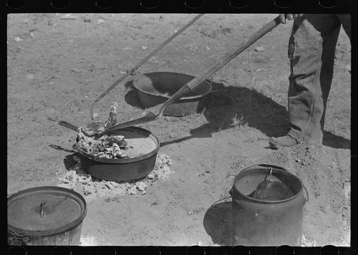 Placing coals on lid of dutch oven for baking bread. Roundup near Marfa, Texas