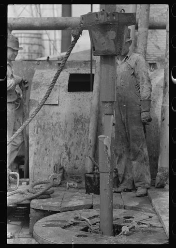 Untitled photo, possibly related to: Roughnecks guiding bailer into hole during bailing out operations, oil well, near Seminole, Oklahoma. They were bailing out mud and water in old well before drilling to a deeper level