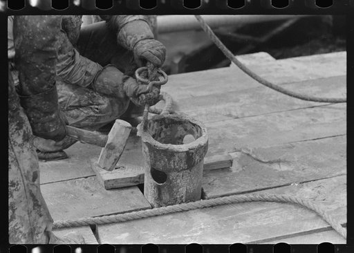 Untitled photo, possibly related to: Roughnecks guiding bailer into hole during bailing out operations, oil well, near Seminole, Oklahoma. They were bailing out mud and water in old well before drilling to a deeper level