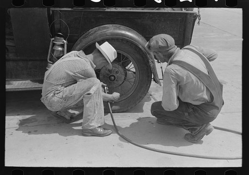Migrants on the road checking tires at filling station near Henrietta [i.e., Henryetta,] Oklahoma