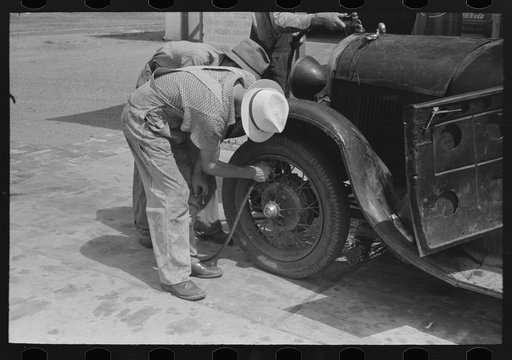 Untitled photo, possibly related to: Migrants on the road checking tires at filling station near Henrietta [i.e., Henryetta,] Oklahoma